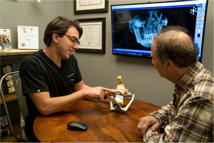 Doctor showing patient model of teeth