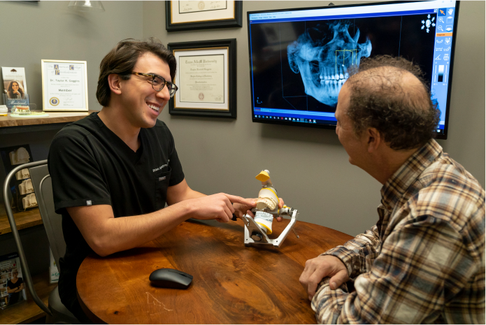 Doctor showing patient model of dentures